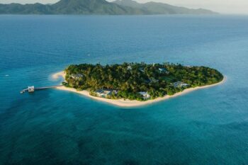 Aerial view of Banwa Private Island in Palawan, surrounded by turquoise waters and lush greenery.